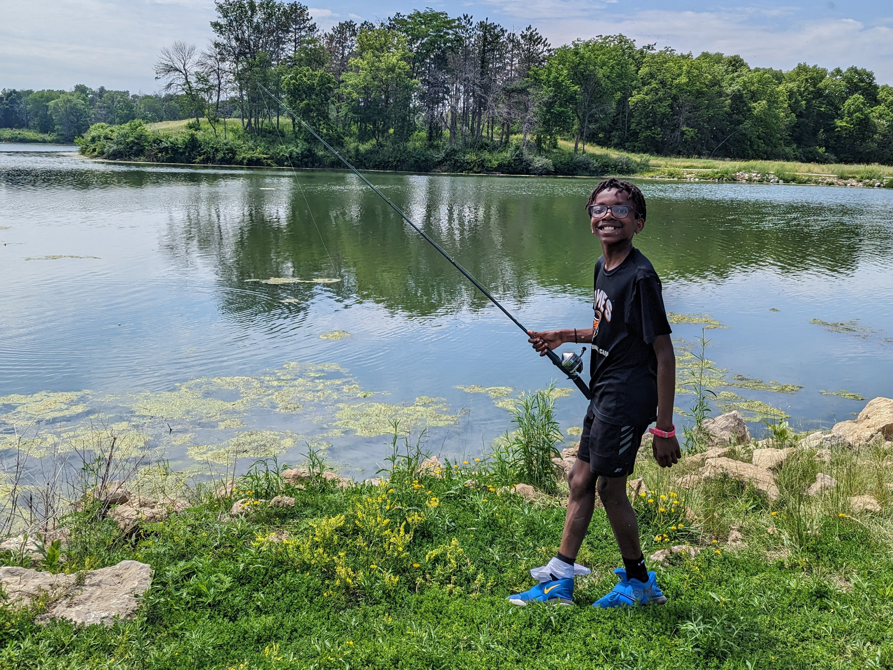 Camper learns to fish on lake shore