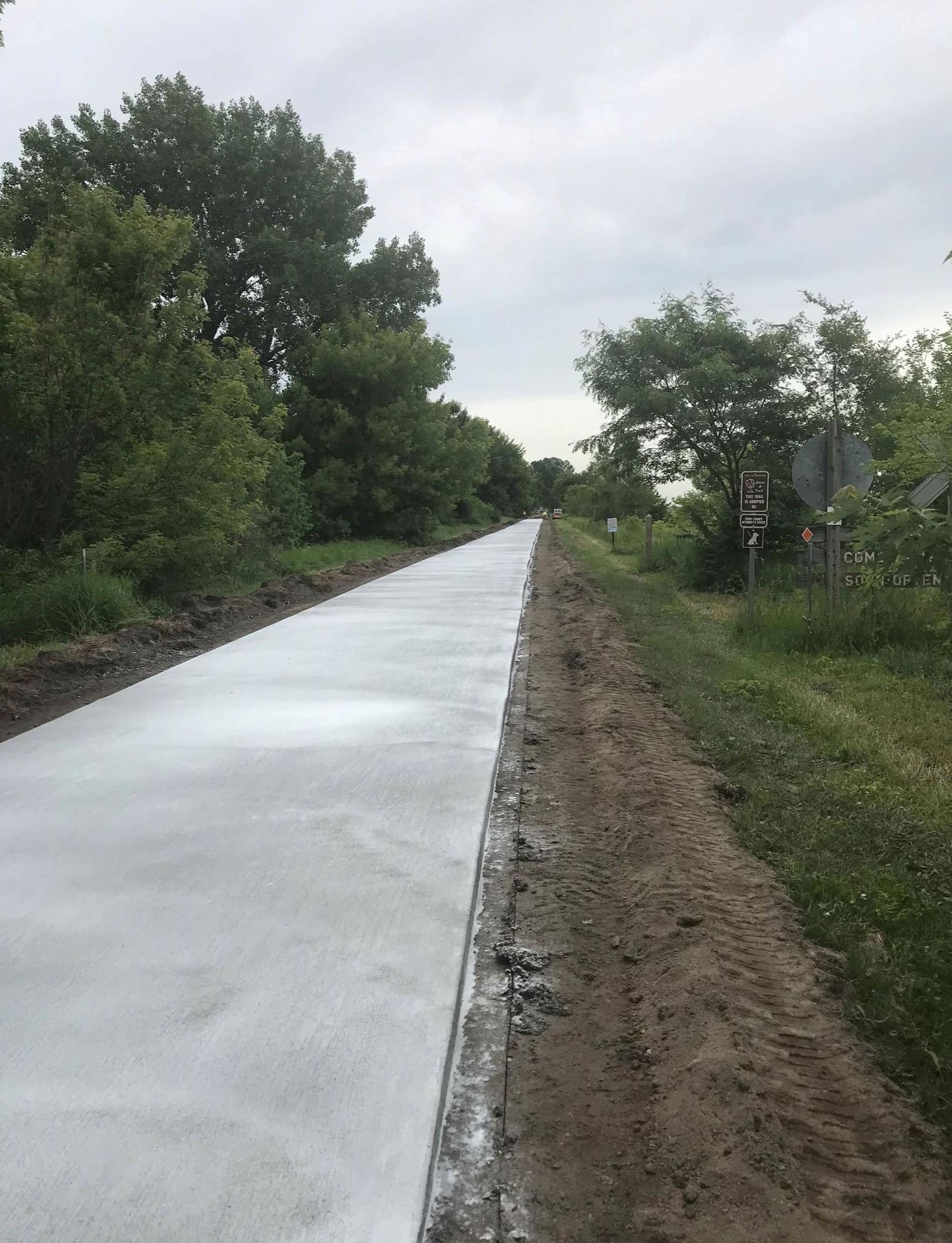 Freshly paved section of Heart of Iowa Nature Trail leads out of sight through nature